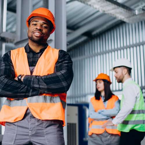 three-factory-workers-safety-hats-discussing-manufacture-plan